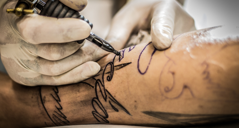 Tatovør laver en tatovering