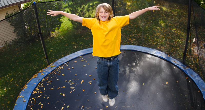En dreng der hopper på trampolin 